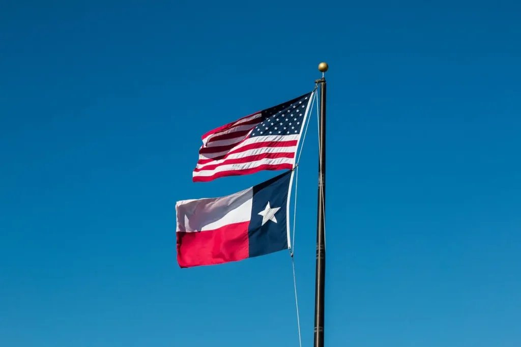 USA & Texas flags flying on a pole