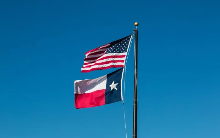 USA & Texas flags flying on a pole