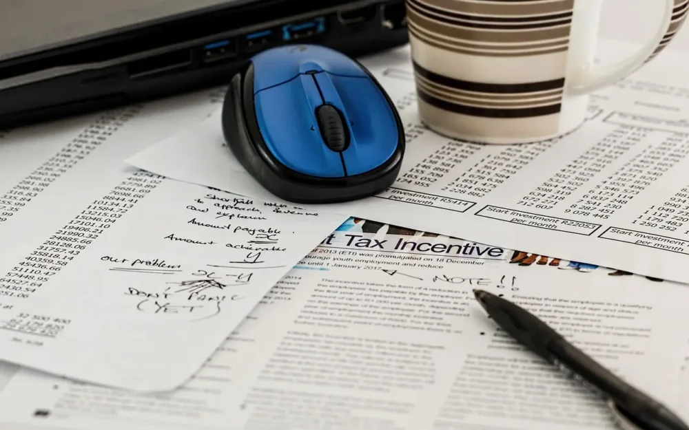 Tax filing documents with computer mouse on top of them